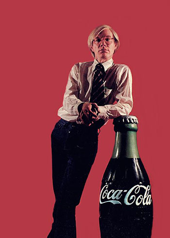 Andy Warhol with Oversized Coca Cola Coke Bottle against Red Background
