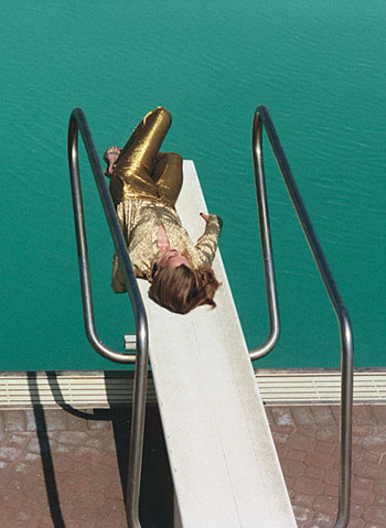 Girl Sunbathing by Pool in Gold Leggings